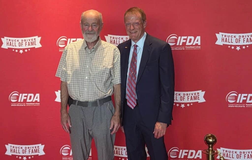 Two men smile toward the camera